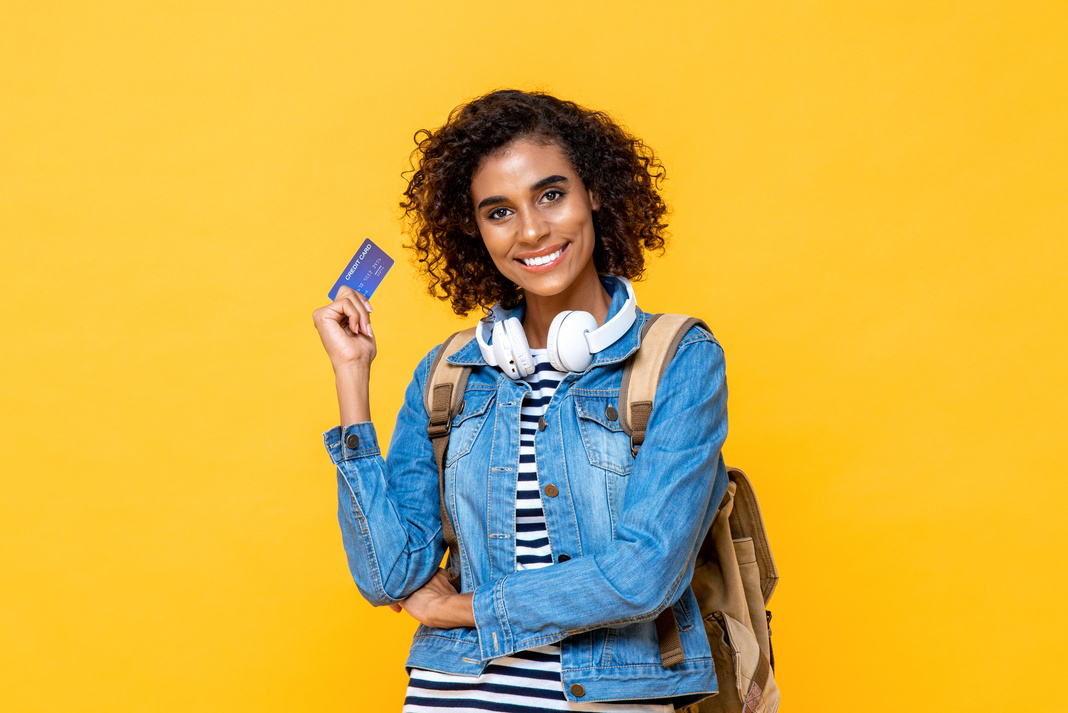 Traveling woman holding credit card.